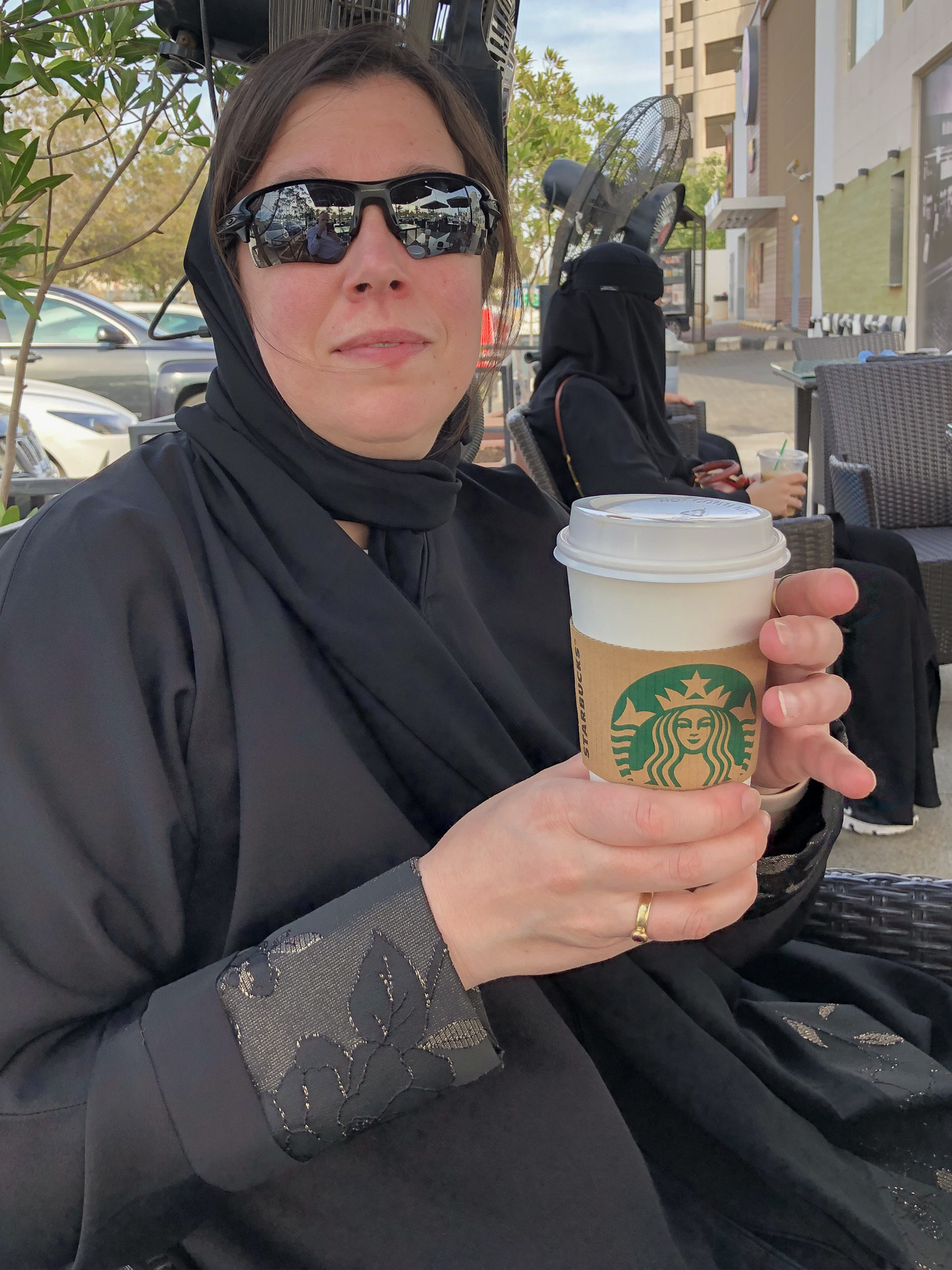 Veschleierte Frau mit Kaffe-to-Go